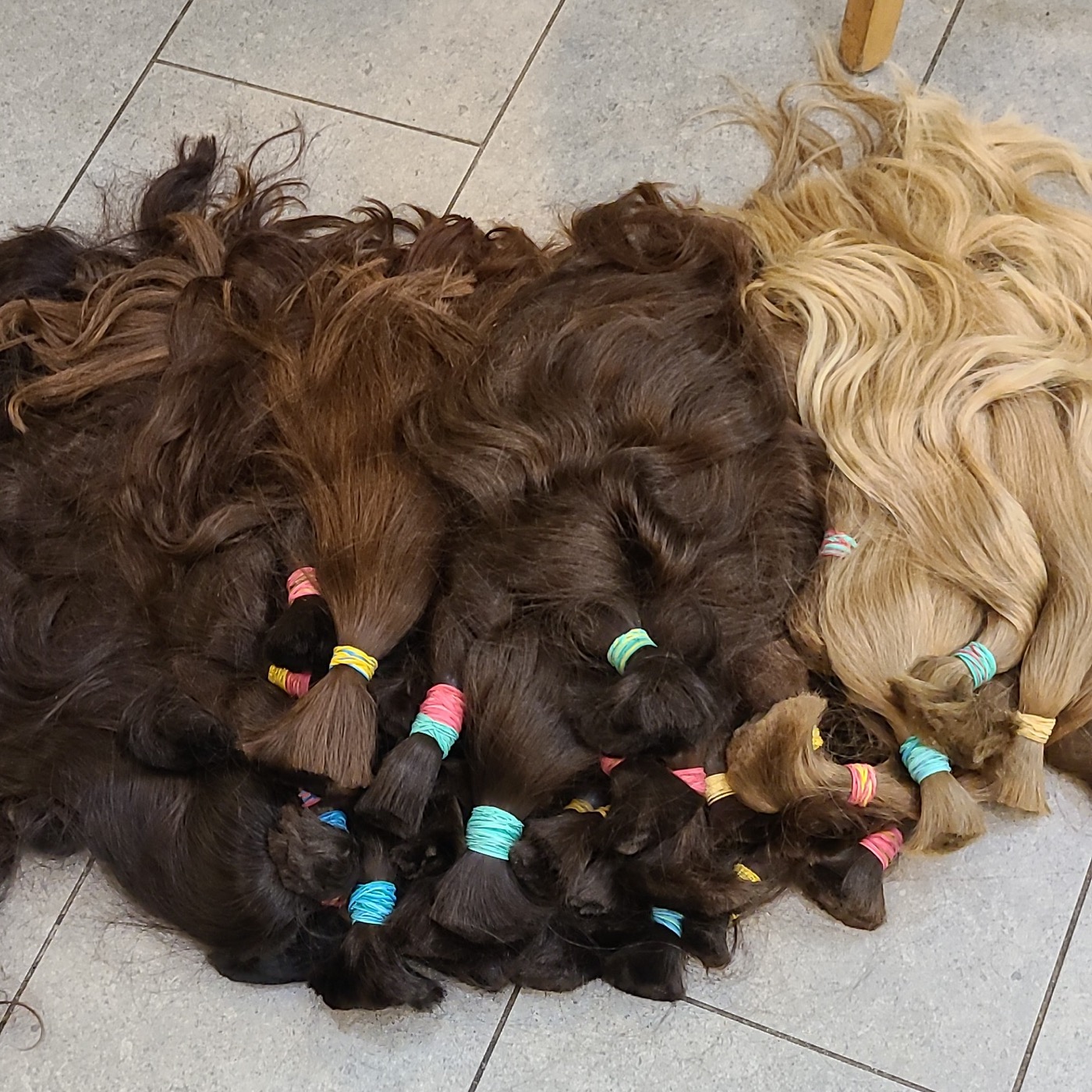 Bundles of brown and blonde human hair tied with colored bands